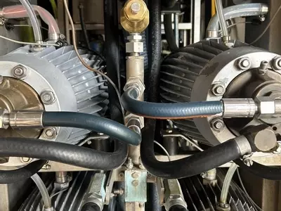 Corroded capillary pipes connected to the pressure manifold on a Nilfisk Delta Booster multi-pump pressure washer before replacement.